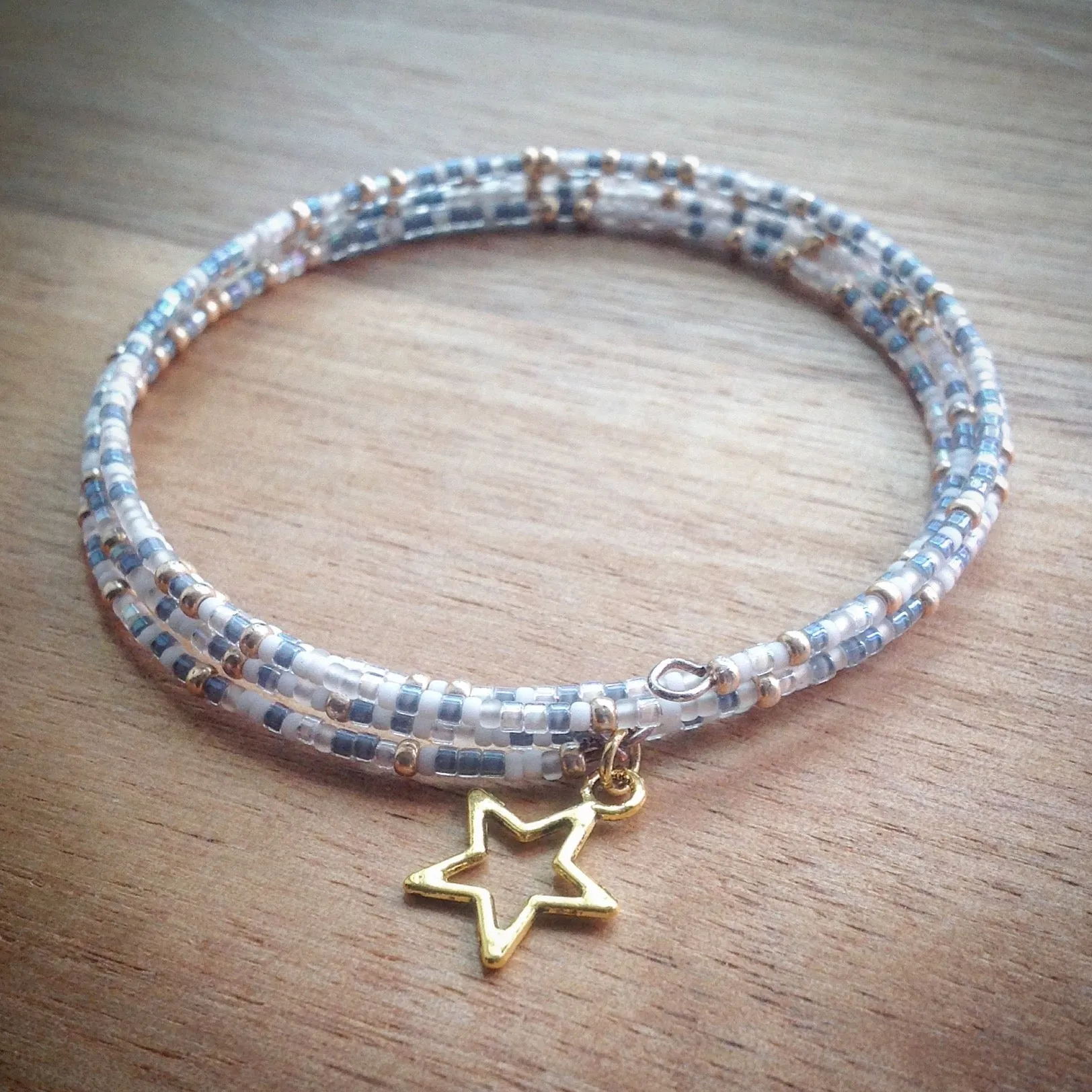 Beaded memory wire bracelet - white, gold and blue/grey seed beads and gold star pendant